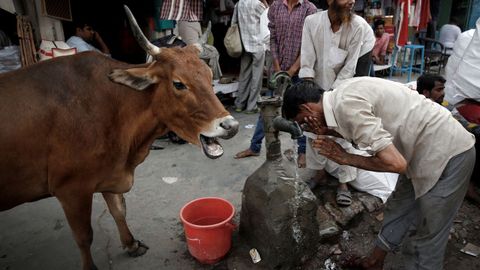 Un hombre se refresca en una fuente durante un da de calor en Delhi, en India