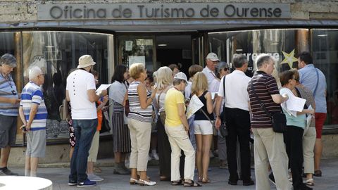 Un grupo de visitantes hace cola a las puertas de una oficina de informacin turstica en la ciudad de Ourense