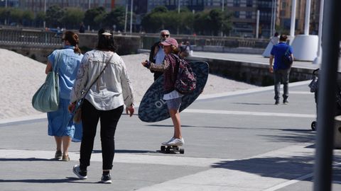 Gente paseando por el paseo marítimo y por la playa en A Coruña