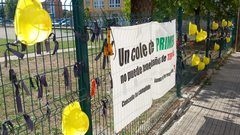 Cascos, lazos negros y una pancarta reivindicativa en el CEIP A Solaina de Nar&oacute;n.