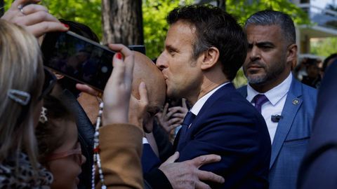 Emmanuel Macron, este domingo, besando a un simpatizante a las puertas de su colegio electoral