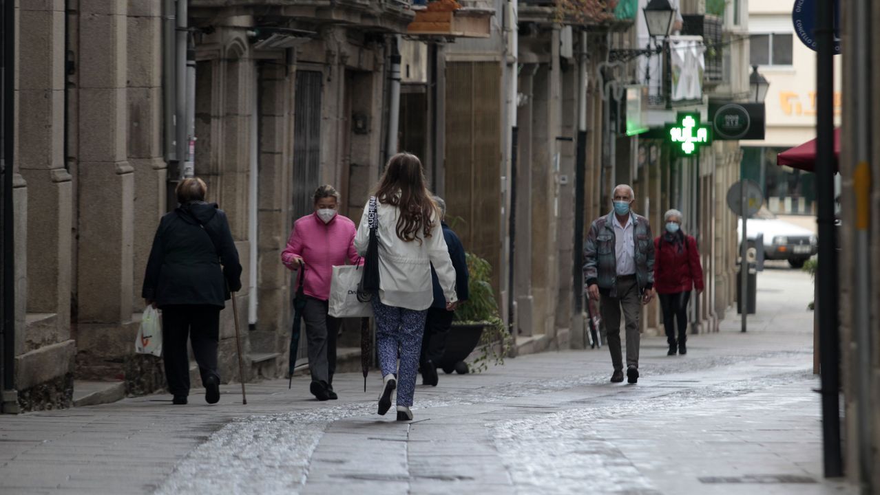 Transentes con mascarillas en la calle Comercio de Monforte