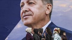 Un grupo de mujeres pasan por un cartel electoral de Erdogan, en Estambul.