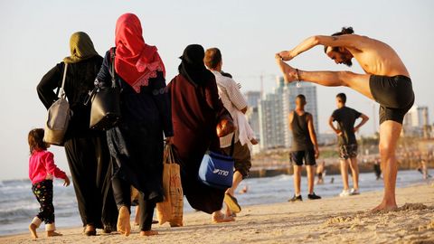 Un grupo de personas disfrutan de un día de sol en la orilla del Mediterráneo en una playa de Tel Aviv