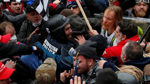 Seguidores de Trump rodean a un policía durante el asalto al Capitolio