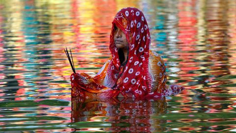 Una mujer hindú se sumerje en las aguas de un lago durante un festival religioso que se celebra estos días en India.