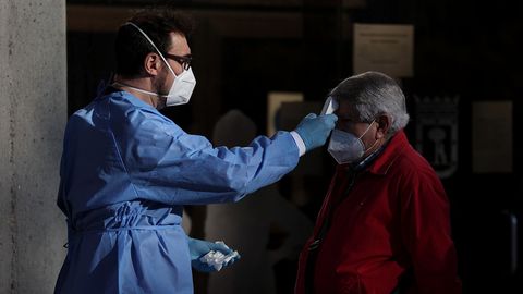 Un sanitario toma la temperatura a un hombre en un centro de mayores de Madrid
