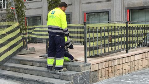 Varios obreros ultiman la colocaci�n de los bancos de La Escandalera