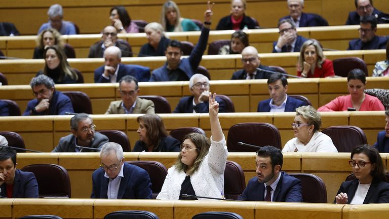 Dos senadores alzan el brazo para votar una de las proposiciones del pleno celebrado en el Senado