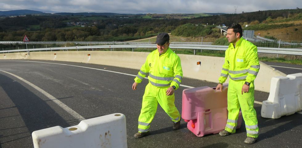 Dos trabajadores retiran los obst�culos que cerraban el paso en la salida del corredor al alto de Oural. 