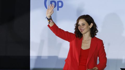 La presidenta de la Comunidad de Madrid Isabel Díaz Ayuso saluda desde el balcón de Génova tras conocer los resultados electorales