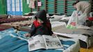 Un niño hojea un periódico en un gimnasio reconvertido en refugio en la ciudad de Leópolis, en el oeste de Ucrania