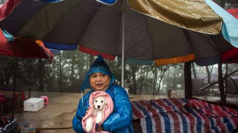 Un hombre cubre a su mascota de dos meses con una manta en un rea vacacional en la provincia china de Hunan.