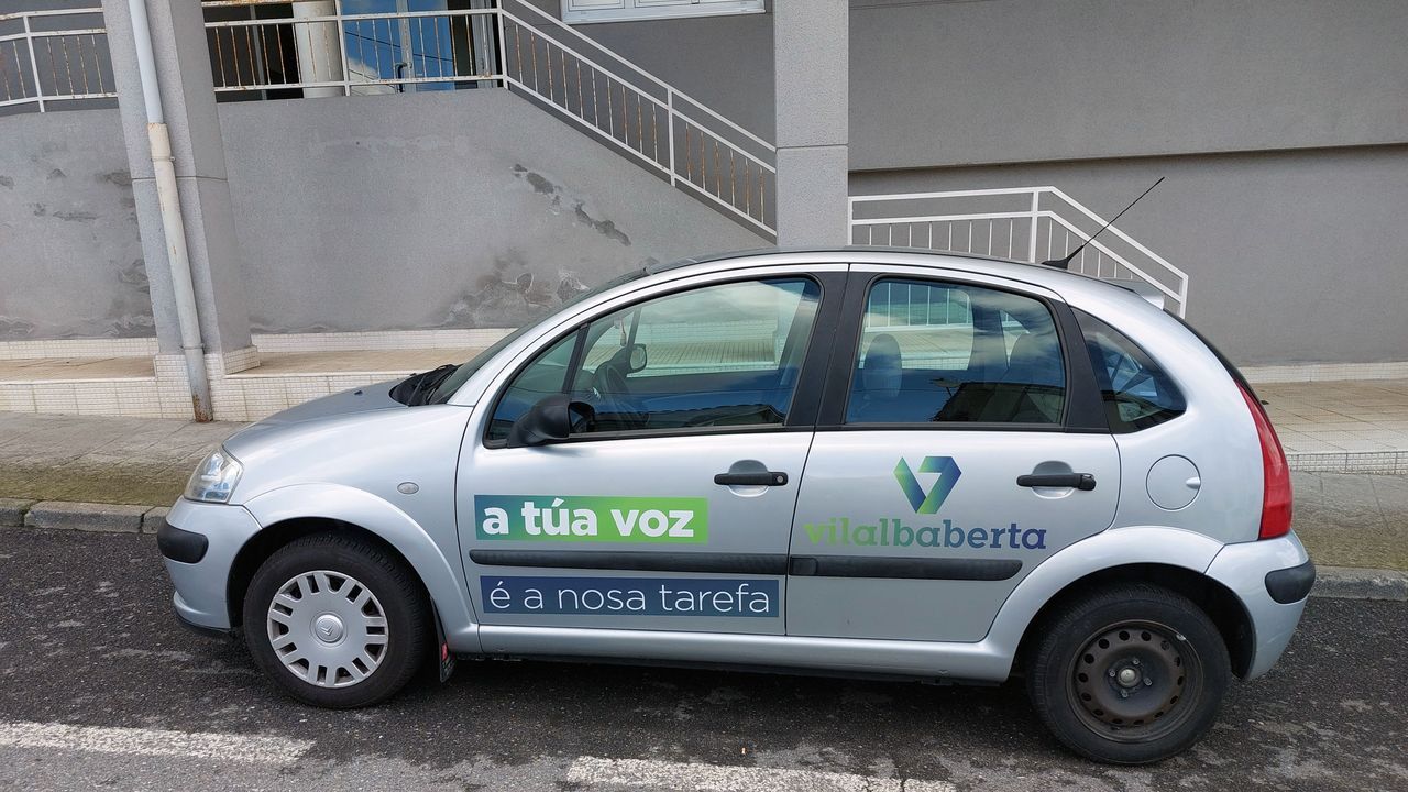 Coche con eslganes de Vilalba Aberta aparcado en una calle de la localidad