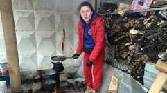 Una mujer cocina en la localidad ucraniana de Chernigov, cuya provincia, la más septentrional de Ucrania y una de las más pobres, fue la puerta de entrada del Ejército ruso para invadir el centro del país.