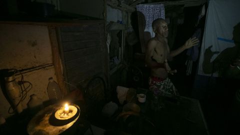 Un hombre se ilumina con una vela, en una vivienda de Santa Marta, en Varadero (Cuba)