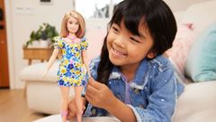 Imagen promocional de Mattel en la que una niña juega con la muñeca
