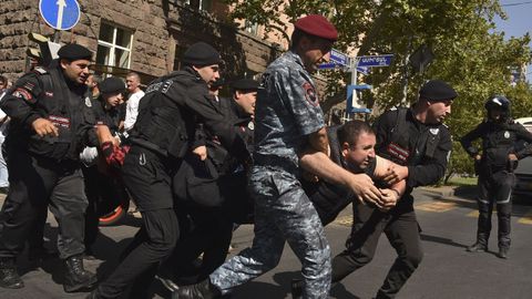 Policías armenios detienen a un hombre durante las protestas.