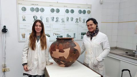 Las restauradoras Silvia Illanes y Carolina Prez, de izquierda a derecha, con la gran vasija una vez completada la restauracin. 