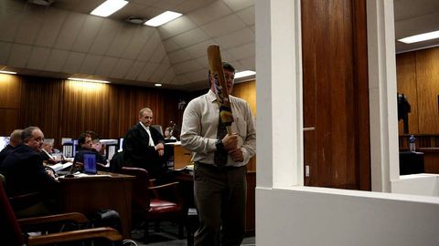 Un polica participa en la reconstruccin de la rotura de la puerta con el bate de crcket durante la octava jornada del juicio contra el atleta paralmpico scar Pistorius