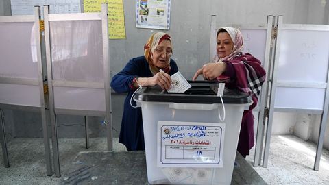Una mujer vota en El Cairo con la ayuda de una asistente, durante las elecciones presidenciales de Egipto