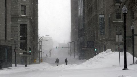 Unos hombres caminan por una calle nevada en Boston.