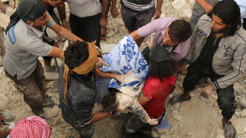 Vecinos se pasan el cuerpo de una nia sacada de los escombros de un edificio bombardeado en el barrio de Al Marja. 