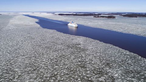 Vista area en la que se ve un ferry navegando a travs del hielo derretido en el canal principal entre las islas del archipilago Merenkurkku, en el oeste de Finlandia