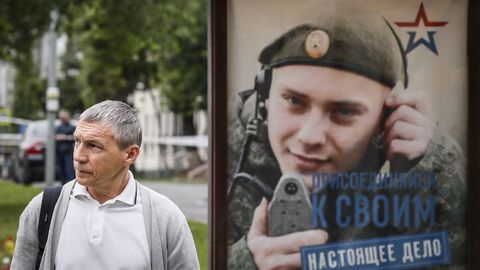 A man walks past an advertisement for the Russian armed forces in Moscow.