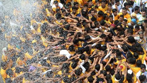 Decenas de devotos son rociados con agua durante las celebraciones en honor al dios Krishna en Bombay (India)