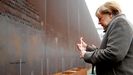 Merkel enciende una vela en la placa que recuerda a las vctimas del regimen comunista