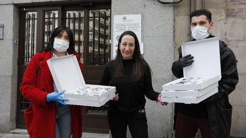 Carla Quintela y lex Fernndez entregan la donacin de burritos a la responsable del comedor de Critas, Ana Vzquez (en el medio).