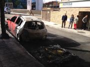 El Renault Cl�o calcinado en la Traves�a de la calle Coru�a de Vigo, observado por la usuaria del coche y los vecinos que oyeron la explosi�n