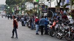 Motoristas hacen cola mientras esperan la apertura de una gasolinera en Caracas