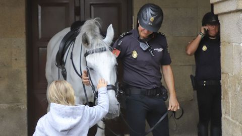 La seguridad se refuerza en Santiago con patrullas a caballo. Una de ellas recibe el saludo de una turista en el casco histrico