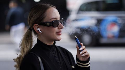 Imagen de archivo de una joven con un dispositivo que calienta el tabaco para fumarlo