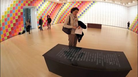 Detalle de una de las salas de la muestra de Holzer en el Guggenheim bilbano, con los Truismos al fondo y uno de los bancos con mensaje grabado, en primer plano