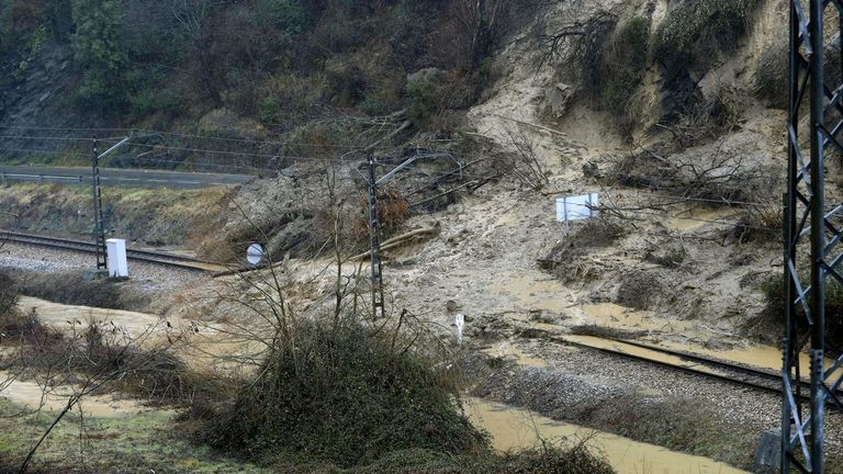 Aspecto que presenta la vía de tren y la carretera comarcal a su paso por Laviana a causa del temporal de lluvias registrado en los últimos días en Asturias