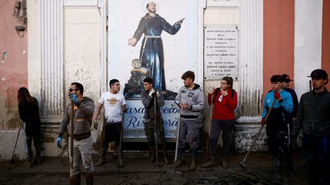 Un grupo de vecinos, este lunes, limpiando el barro en las calles de Ischia
