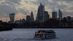 Un barco fluvial cruza el río Támesis mientras el sol se pone en Londres