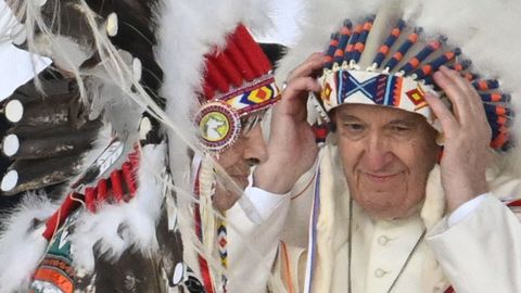 El papa Francisco se coloca un casco de guerra indígena durante la ceremonia
