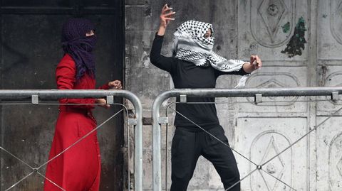 Una joven mujer palestina lanza piedras contra las fuerzas de seguridad israeles en Hebrn.