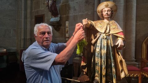 Antonio lvarez, poniendo el racimo de uvas que seleccion este ao en la mano del Apstol, en la parroquia de As Caldas