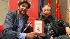 El editor Guillermo Bravo, de Mil Gotas, ensea el libro junto al hispanista Zhao Zhenjiang