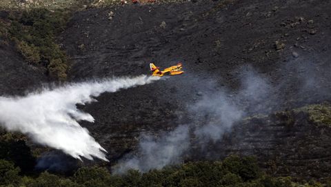 Un avión echa agua sobre el fuego en un incendio en Vilariño de Conso el mes pasado