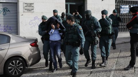 Uno de los detenidos en Ourense, rodeado de guardias civiles a la salida tras el registro de una casa en la calle Burgas