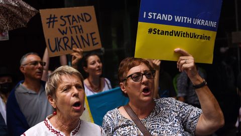 Manifestantes sostienen pancartas durante una concentración contra la guerra en Ucrania en el Martin Place de Sídney, Australia.
