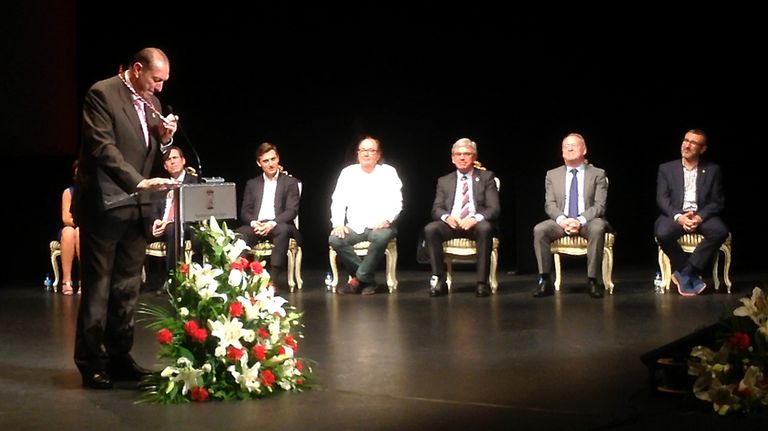Quini sostiene, emocionado, la medalla que le reconoce como Hijo Adoptivo de Gijón ante los portavoces municipales, en el teatro Jovellanos