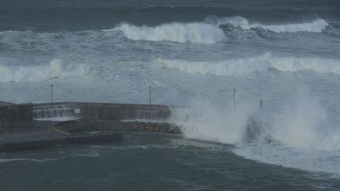 Foto de las olas saltando el dique de abrigo de Cain en medio de un temporal