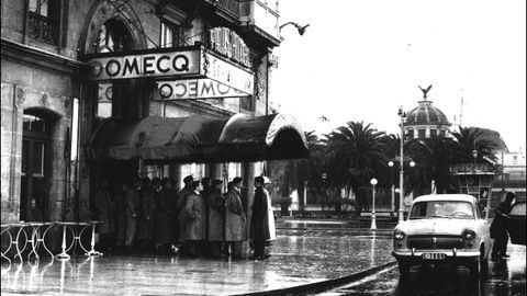 Coruñeses se cobijan bajo el toldo del hotel Palace en un día lluvioso del mes de febrero de 1960
